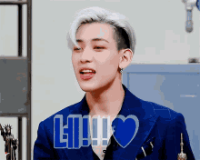 a man in a blue suit has a heart and the word lii written on his face