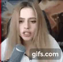 a woman is talking into a microphone and making a face .