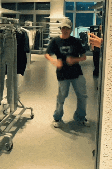 a man taking a picture of himself in a mirror in a clothing store