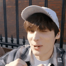 a young man wearing a white hat with the word milky on the sleeve