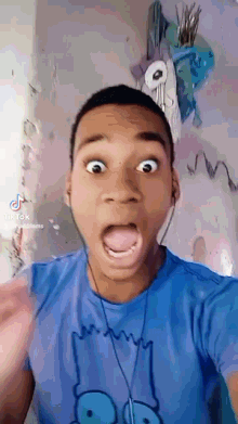 a man wearing a blue shirt with bart simpson on it making a funny face