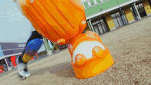a person is standing next to a large orange and white object