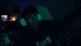 a man wearing headphones and a shirt that says ghost is dancing in a dark room