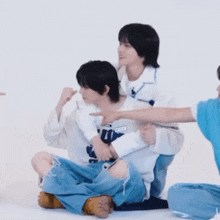 a group of young men are sitting on the floor and one of them is wearing a sweatshirt that says ' i love you '
