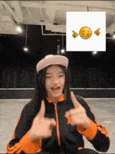 a girl wearing a hat giving a thumbs up in front of a smiley face
