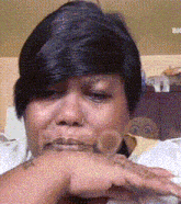 a woman with a nose ring is crying with her hand on her face