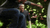 a man in a black shirt is squatting down next to another man in a black shirt