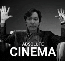 a black and white photo of a man with his hands in the air and the words absolute cinema below him
