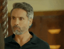 a man with a beard and a black shirt looks surprised