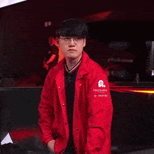 a man in a red jacket and glasses is holding a sword in his hand .