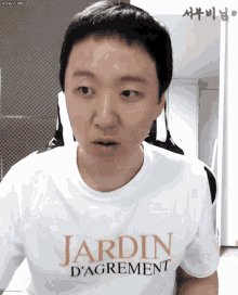 a man wearing a white t-shirt that says jardin d' agreement