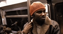 a man wearing an orange hat is standing on a bus