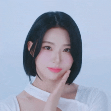a woman with short black hair is wearing a white shirt and pink lipstick