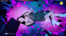 a woman in a leopard print dress is laying on a pile of ticket stubs