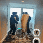 a group of people are standing in a hallway holding a large wooden block