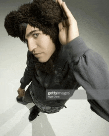 a man wearing a bear hat and a gray sweatshirt is taken by nigel crane