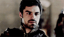 a man with a beard is wearing a black and gold jacket