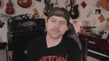 a man wearing a black shirt that says ' atomic ' on the front