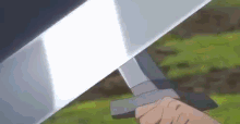 a person is holding a sword with a light coming out of it .