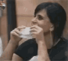 a woman is drinking a cup of coffee from a cup .