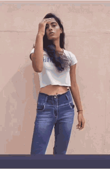 a woman wearing a crop top that says aat80 on it