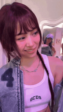 a woman wearing a white tank top with gcds written on it