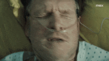a man in a hospital bed with an oxygen tube in his nose
