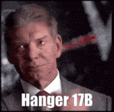 a man in a suit and tie with the words hanger 17b on the bottom