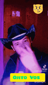 a man wearing a cowboy hat is making a gesture with his hand
