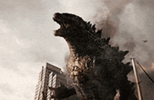 a statue of a monster is standing in front of a building .