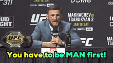 a man speaking into a microphone in front of a ufc sign