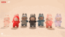 a group of stuffed animals are lined up in a row with a pop mart logo behind them
