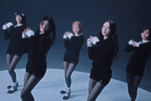 three women in black clothes are dancing in a circle