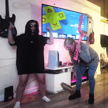 a man and a woman are dancing in front of a tv screen that says xbox live