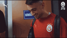 a man in a red shirt is smiling in front of a door that says giris