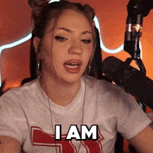 a woman in front of a microphone is saying i am