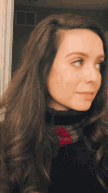 a woman with long brown hair is wearing a black turtleneck