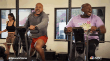 two men are riding exercise bikes in a gym with the nbc logo on the bottom