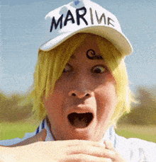 a man wearing a white hat with marine written on it