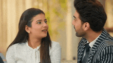 a man and a woman are looking at each other and talking .