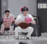 a man squatting down holding a bowling ball with korean writing on the bottom right