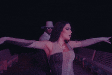a woman with a butterfly necklace is dancing with a man behind her