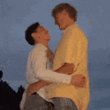 a man in a yellow shirt kisses a woman in a white shirt