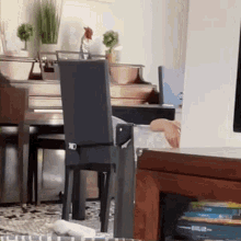 a person sits in a chair in a living room with a bible on the table