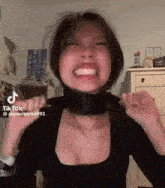 a woman wearing a black shirt and a black scarf around her neck .