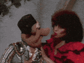 a woman in a red dress is touching a puppet