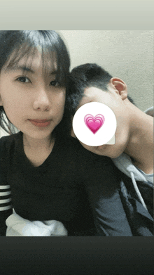 a girl and a boy are posing for a picture with a pink heart on their face