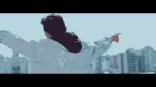 a man with his arms outstretched is pointing at something in the distance