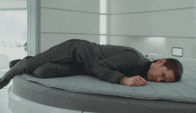 a man in a suit is laying on a mattress