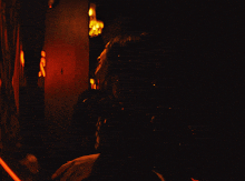 a blurred image of a person in a dark room with a light behind them